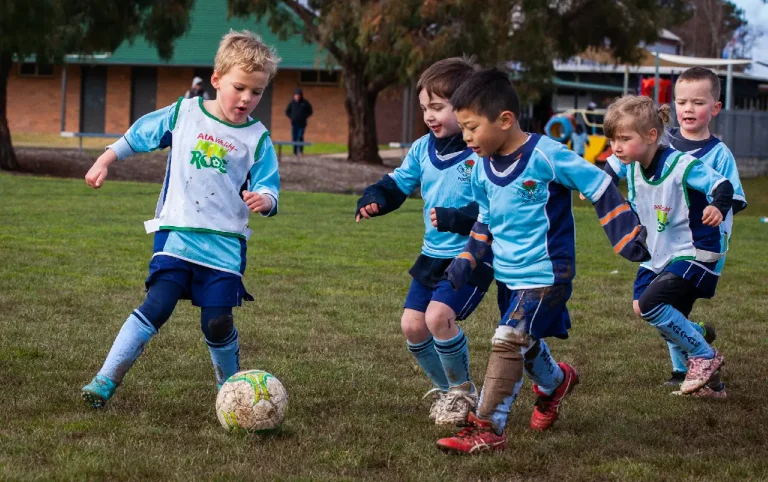 five junior soccer players in blue with ball